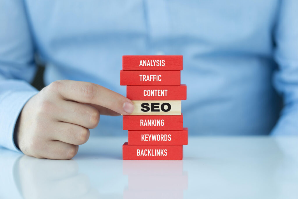 Person using Jenga blocks to give a visual to asking does your company need SEO