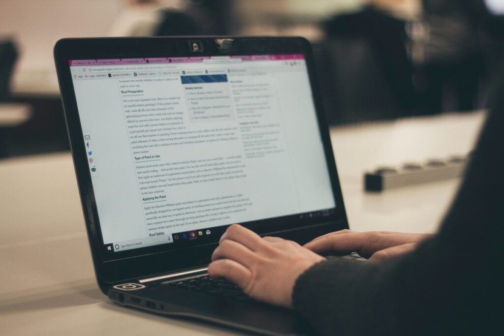 Person typing on laptop with text relating to the question how does a blog help SEO